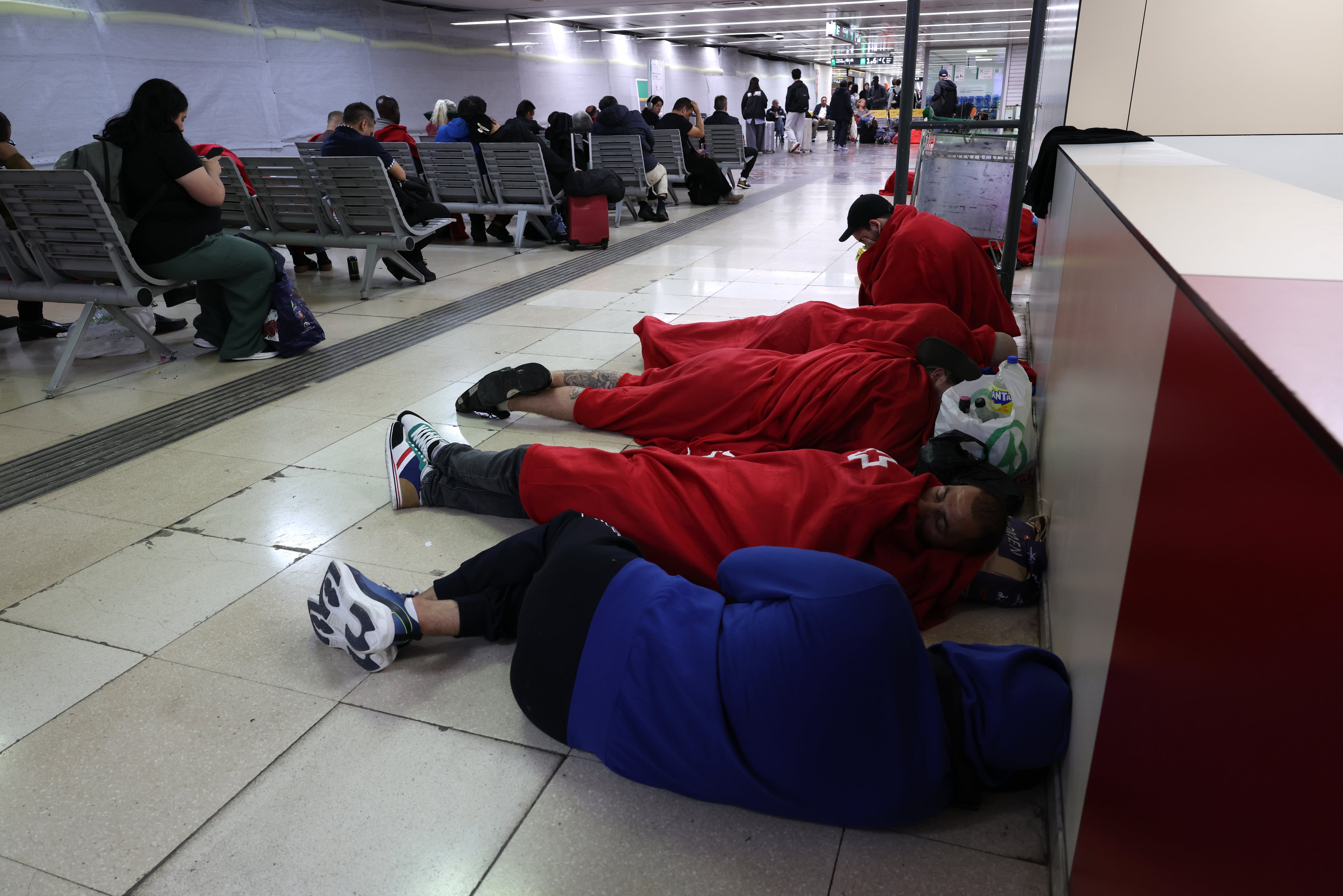 Viajeros pasan la noche en la estación de Sants de Barcelona, este domingo.