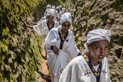 Un grupo de mujeres jóvenes atraviesan la cueva de San Jorge, en la iglesia con el mismo nombre en Lalibela, Etiopía, este lunes, durante el festival Ashenda, que se celebra en las regiones de Tigray y Amhara. 

