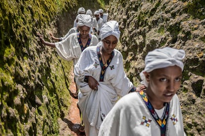Un grupo de mujeres jóvenes atraviesan la cueva de San Jorge, en la iglesia con el mismo nombre en Lalibela, Etiopía, este lunes, durante el festival Ashenda, que se celebra en las regiones de Tigray y Amhara. 
