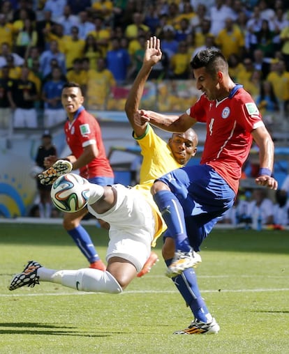 El defensa chileno Mauricio Isla lucha un balón con el centrocampista brasileño Fernandinho