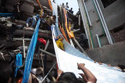 Una mujer es rescata del edificio derrumbado en Dacca (Bangladesh). Los medios locales sitúan la cifra de heridos entre 600 y 800 personas en uno de los peores siniestros industriales en la historia del país asiático.