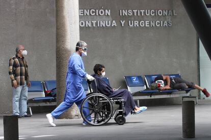 Un enfermero empuja a un paciente en silla de ruedas, en un hospital en Ciudad de México.