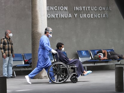 Un enfermero empuja a un paciente en silla de ruedas, en un hospital en Ciudad de México.