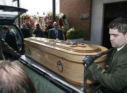 Empleados de los servicios funerarios portan el féretro que contiene el cuerpo del humorista, en el cementerio de La Almudena.