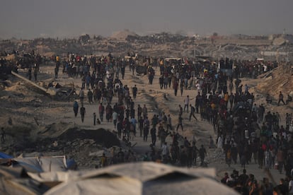 Centenares de palestinos caminan hacia una zona donde entran camiones con ayuda humanitaria, en Ciudad de Gaza, este viernes. 