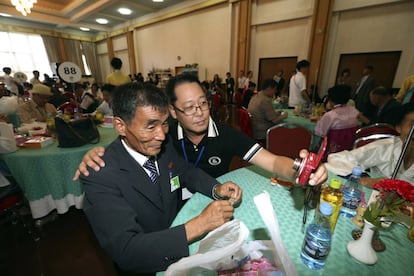 O norte-coreano Lim Jong Sun, de 57 anos, tira fotos com seu parente sul-coreano Min Jae-hong, de 44 anos.