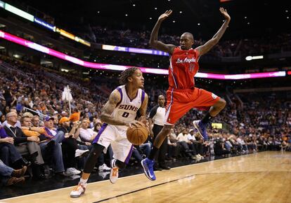 Jamal Crawford de Los Ángeles Clippers salta delante del jugador de los Phoenix Suns Michael Beasley.