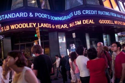 Los rótulos de neón de la plaza de Times Square, en el centro de Nueva York, informan de la rebaja de calificación de la deuda estadounidense.