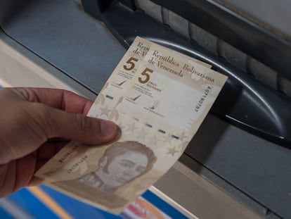 Una persona saca dos billetes de 5 bolívares digitales, la nueva divisa venezolana, este viernes en Caracas.