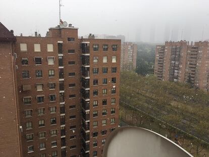 Copos de nieve cayendo esta mañana en el barrio del Pilar de Madrid.