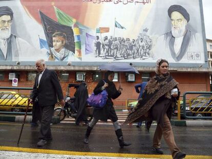 Pedestres passam por outdoor do líder supremo iraniano.