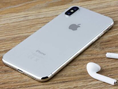 Los auriculares AirPods de Apple junto a un iPhone.