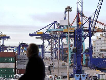 Dos personas observan, desde el edificio Veles e Vents de la Marina de Valencia, los trabajos de estiba en varios barcos. 