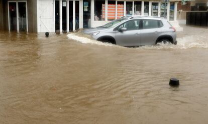 Un coche circula por una calle inundada en Xàbia (Alicante).