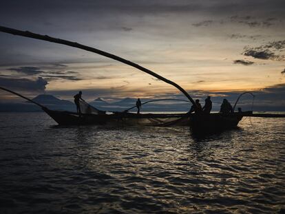 La tripulación del capitán Semuliki Bahati trabaja al amanecer en un pesquero de tres cascos llamado 'yorogo' en lengua kihavu. Al fondo se alza el volcán activo Nyiragongo (izquierda) y los inactivos Mikeno y Karisimbi, en los montes Virunga. El grupo zarpa al anochecer y se queda en el lago hasta las primeras luces del día. Luego, sus jóvenes miembros, agotados por el duro trabajo y el manejo de las grandes redes, vuelven a puerto y reparten las escasas ganancias de la captura.