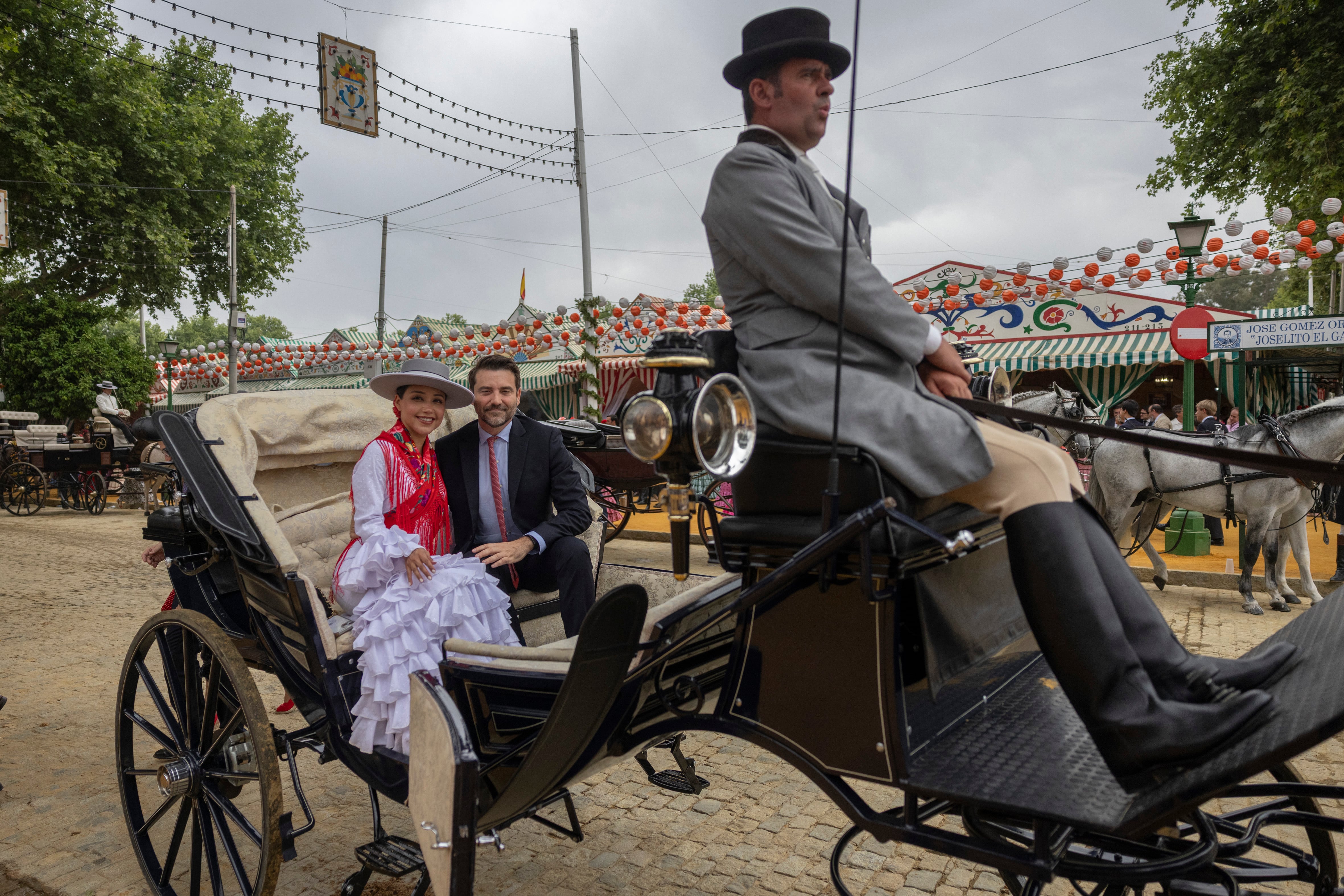 Javier Negre y su pareja, Astrid Macías, posan para una fotografía en un coche de caballos en la feria de Sevilla, el 21 de abril.
