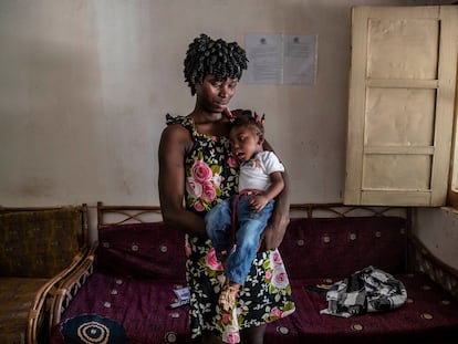 Ismene Henriqueta Quintino, de 23 años, sostiene a su hija Jean Philippe, de un año, con parálisis cerebral a la que su familia quiso matar al considerarla una 'irã' (no humana).