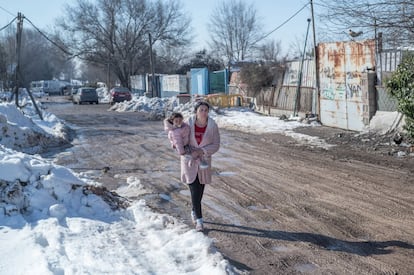 Una mujer con un bebé caminando por una zona llena de barro del sector 6. Los márgenes del camino se encontraban llenos de hielo y nieve de la borrasca Filomena.