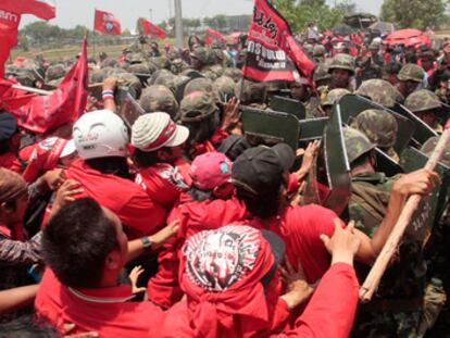 <i>Camisas rojas</i> se enfrentan a soldados durante el asalto a la principal estación de comunicaciones de Tailandia.