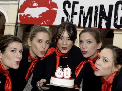 Un grupo de azafatas de la Seminci sopla las velas de una tarta para celebrar el 60ª aniversario del festival.