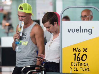 Pasajeros hacen cola ante el check-in de Vueling en el aeropuerto de El Prat.