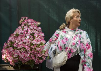 Una mujer sujeta la planta que ha comprado en la feria floral.