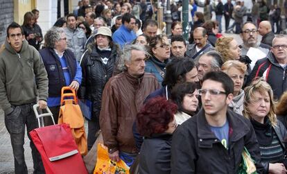 Cola de vecinos en el barrio de Orriols, ayer sábado, para recoger comida del partido España 2000.