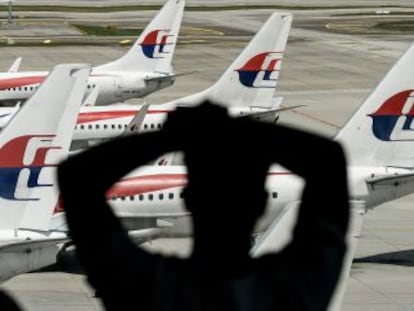 Un hombre mira un avi&oacute;n de Malaysia Airlines en el aeropuerto de Kuala Lumpur, el pasado 25 de febrero.