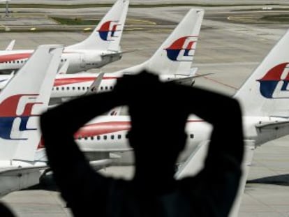 Un hombre mira un avión de Malaysia Airlines en el aeropuerto de Kuala Lumpur, el pasado 25 de febrero.