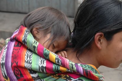 A 12-year-old girl carries her baby.