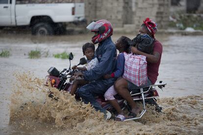 Un hombre conduce una motocicleta por una calle, en Leogane, Haití.