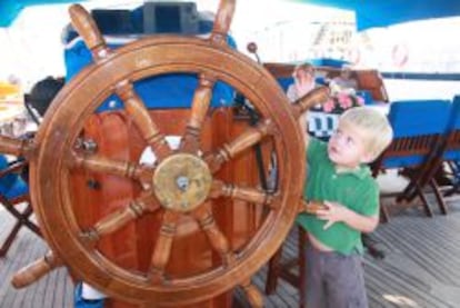 Ni&ntilde;o jugando con el tim&oacute;n de una goleta.