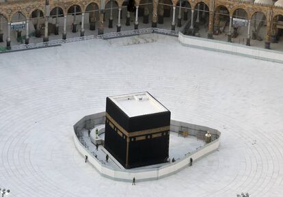 Agentes de la policía vigilan la Kaaba, el gran cubo que se encuentra en la Gran Mezquita de La Meca, en Arabia Saudí, el pasado 6 de marzo. El lugar santo de los musulmanes se encontraba vacío en una medida para intentar luchar contra la epidemia del coronavirus.