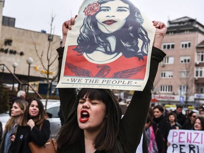 Mulher com um cartaz que diz “Nós, o povo, defendemos a dignidade”, durante manifestação em Kosovo em março.