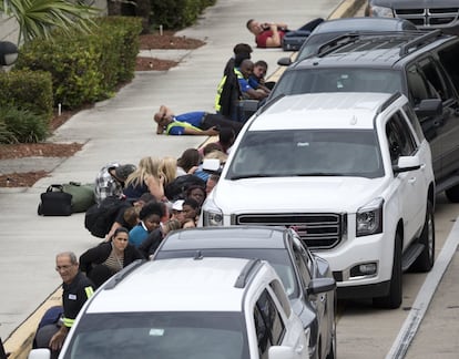 Un grupo de personas agazapadas frente al Aeropuerto Internacional Hollywood en Fort Lauderdale, Florida (EE UU), el 6 de enero de 2017, donde un hombre abrió fuego en un terminal matando al menos a cinco personas.