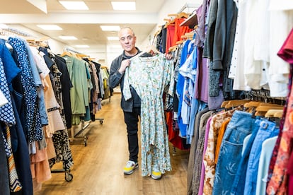   Javier Gutiérrez shows one of the garments from the Cáritas Moda clothing store.