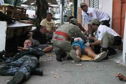Un hombre herido de bala es atendido en medio de un enfrentamiento entre fuerzas de seguridad y narcotraficantes en la favela de La Grota.