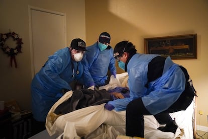 Sanitarios de emergencias trasladan a un paciente de covid-19 de su casa a un centro sanitario en Placentia, California.