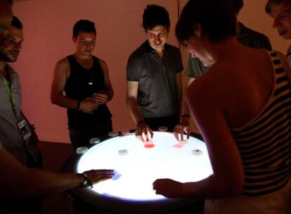 Varios visitantes del Sónar interactúan con Reactable, la famosa mesa que permite crear todo tipo de música, y desarrollada desde Barcelona.