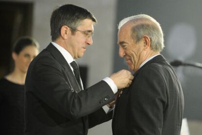 Patxi López coloca a Carlos Garaikoetxea la distinción del Árbol de Gernika, la más importante que concede el Gobierno vasco.
