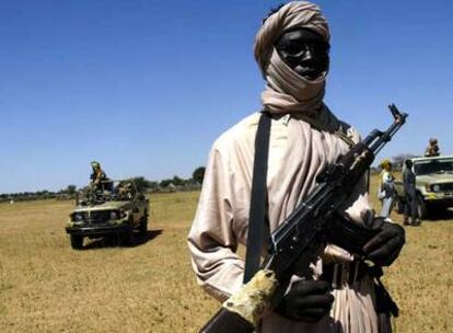 Un rebelde sudanés armado vigila ante dos vehículos de la Unión Africana en Muhajiriya, al sur de Darfur, en 2005.