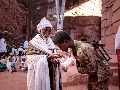 Un miliciano amhara aliado del Ejército etíope besa una cruz sostenida por un cura ortodoxo en Lalibela tras la recuperación de esta ciudad por el Gobierno federal.