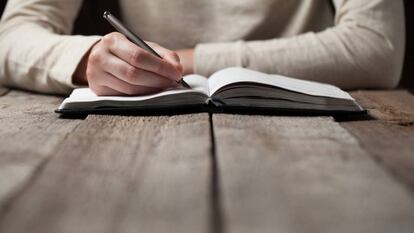 Una mujer escribe en un cuaderno.