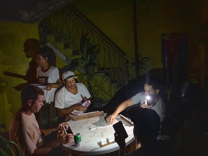 Un grupo de cubanos juega dominó en pleno apagón en La Habana.