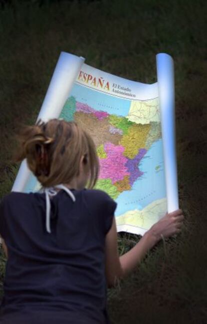 Una joven consulta un mapa autonómico de España.