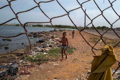 Dos niños juegan en una playa contaminada a lo largo del lago Maracaibo, cerca del mercado central de Maracaibo, el 7 de mayo de 2019.