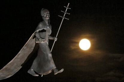 Lluna plena, l'última superlluna d'aquest any, s'aixeca prop d'una estàtua del papa Lleó IX a Eguisheim, Eathern, França.