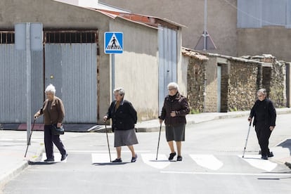 Four residents cross a street in Pescueza.