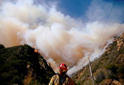 Un bombero trabaja en uno de los focos del incendio que se ha producido en Malibú (California).