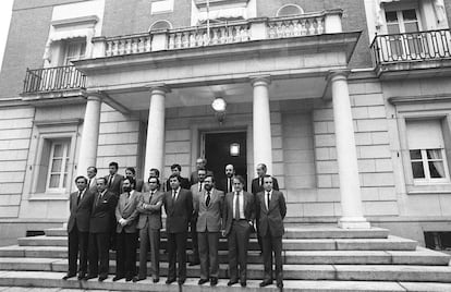 Foto de familia del primer Gobierno del PSOE tras su victoria en las elecciones legislativas de octubre de 1982, hecha en las escaleras de acceso al Palacio de La Moncloa de Madrid. Primera fila, de izq. a dcha.: José Barrionuevo, ministro del Interior; Fernando Ledesma, ministro de Justicia; Narcís Serra, ministro de Defensa; Alfonso Guerra, vicepresidente; Felipe González, presidente del Gobierno; Javier Solana, ministro de Cultura; Javier Moscoso, ministro de la Presidencia; y José María Maravall, ministerio de Educación y Ciencia. Segunda fila, de izq. a dcha.: Tomás de la Quadra, ministro de Administración Territorial; Ernest Lluch, ministro de Sanidad; Carlos Romero, ministro de Agricultura; Carlos Solchaga, ministro de Industria y Energía; Enrique Barón, ministro de Transportes, Turismo y Comunicaciones; Julián Campo, ministro de Obras Públicas y Urbanismo; Joaquín Almunia, ministro de Trabajo; y Fernando Morán, ministro de Asuntos Exteriores. En la última fila, solo: Miguel Boyer, ministro de Economía y Hacienda.